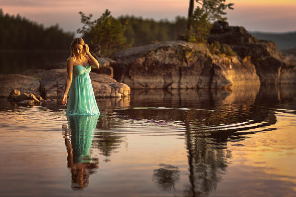 porträtt av kvinna i grön kjol som står i sjön