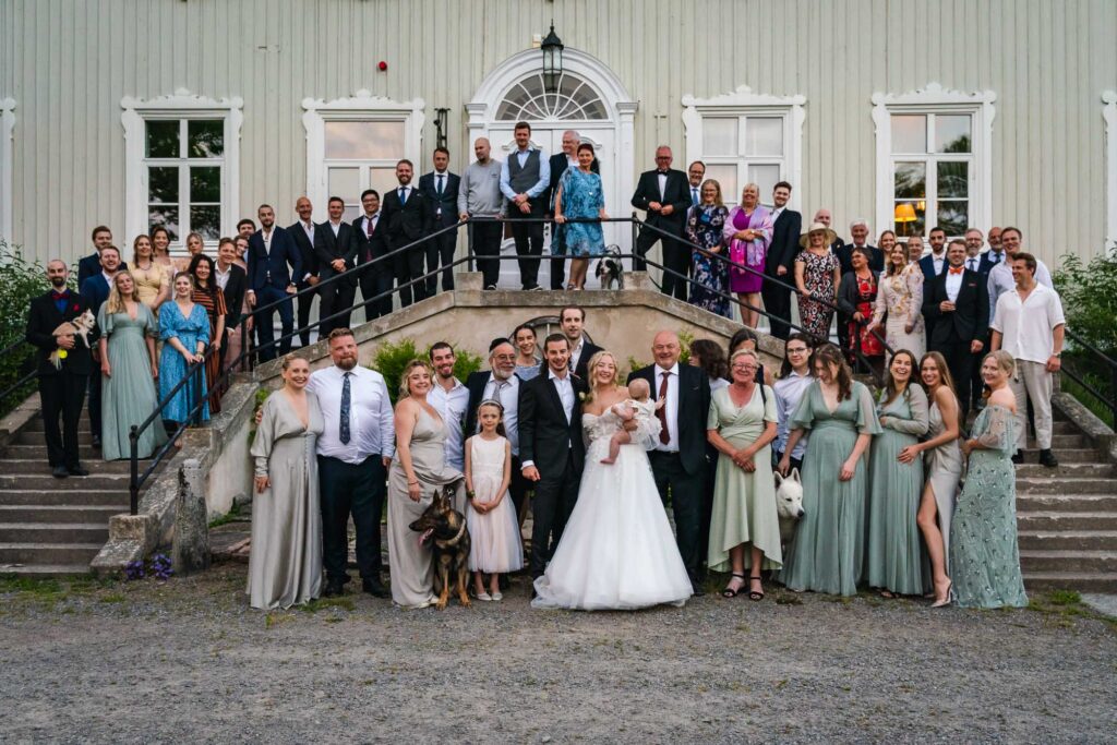 Gruppfoto av brudpar med familj och gäster på Krokstad herrgård