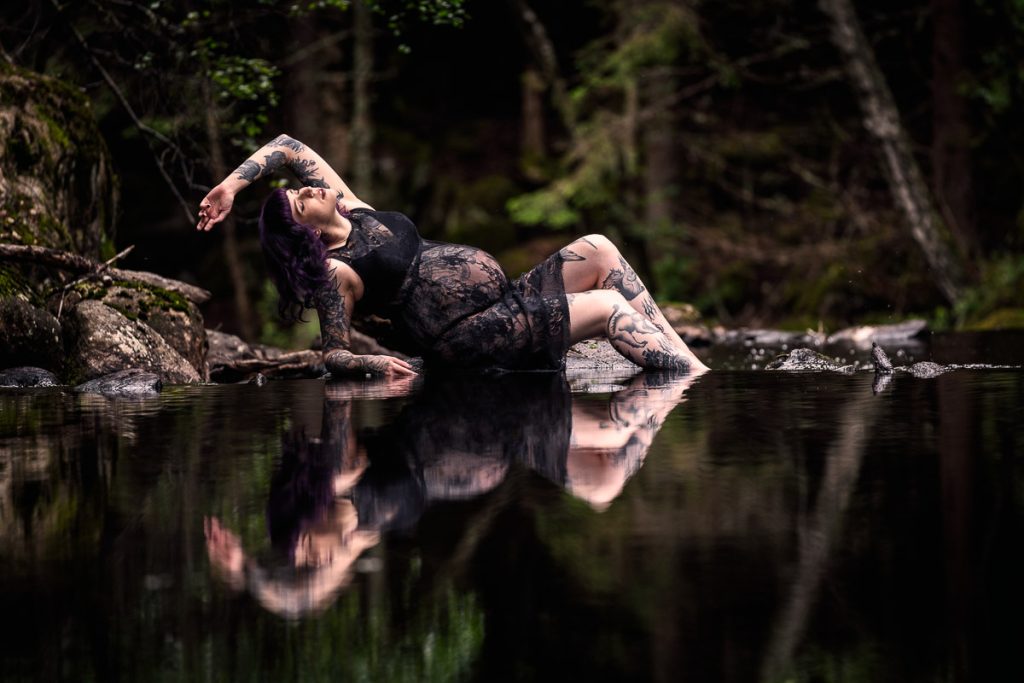 Bild av gravid kvinna som speglas i en damm.