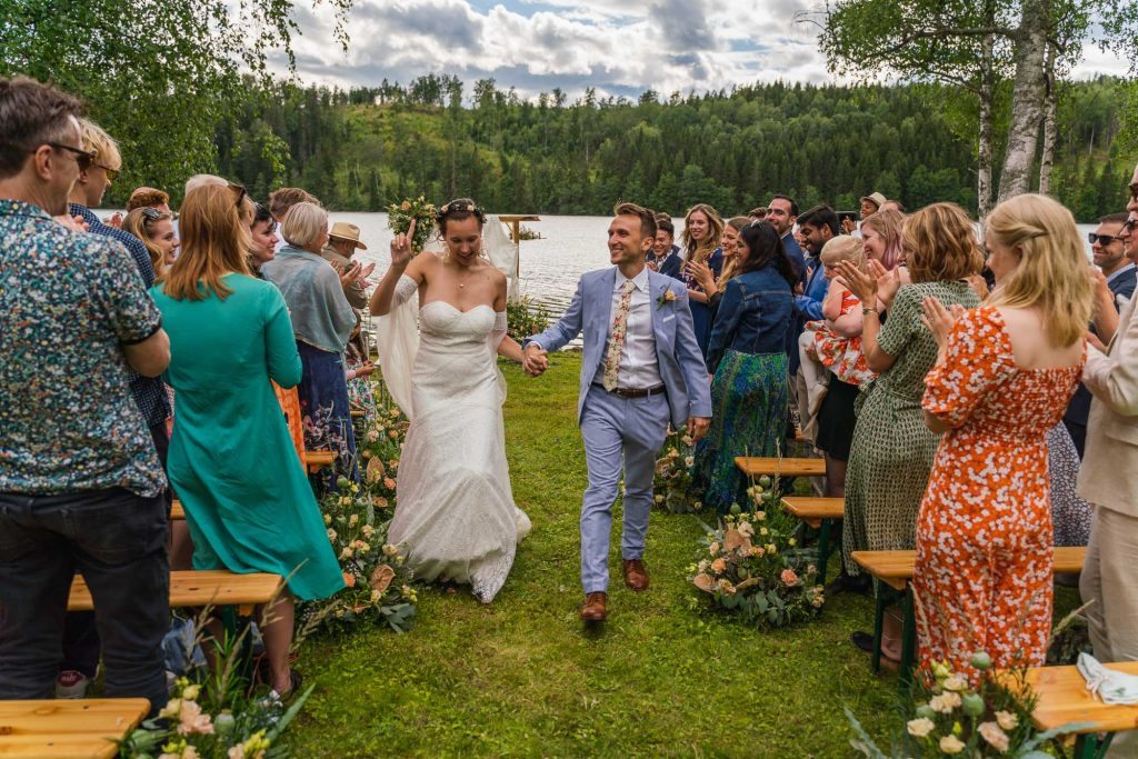 Bröllopsparet går ut från bröllopet mellan bröllopsgästerna i Alster Karlstad Värmland