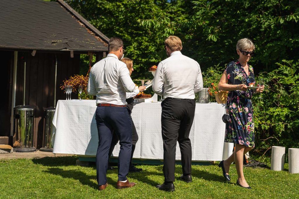 Bröllopsgästerna hämtar tårta och champagne.