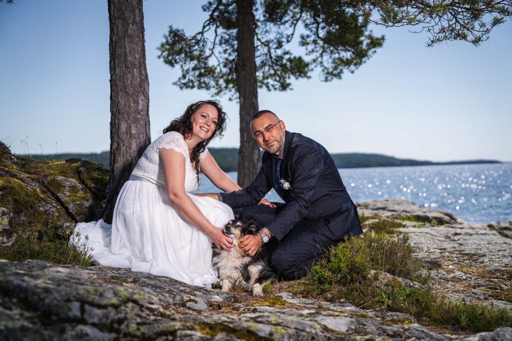 Brudparet tillsammans med sin hund utanför västra Fågelviks kyrka i Töcksfors.