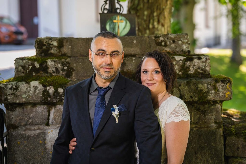 Brudparet poserar framför grunden till västra Fågelviks kyrka.