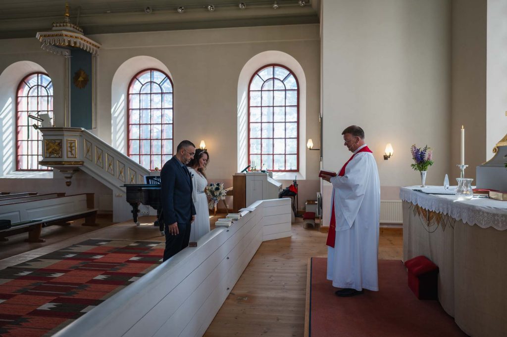 Prästen läser ur bibeln för brudparet i västra Fågelviks kyrka i Töcksfors.